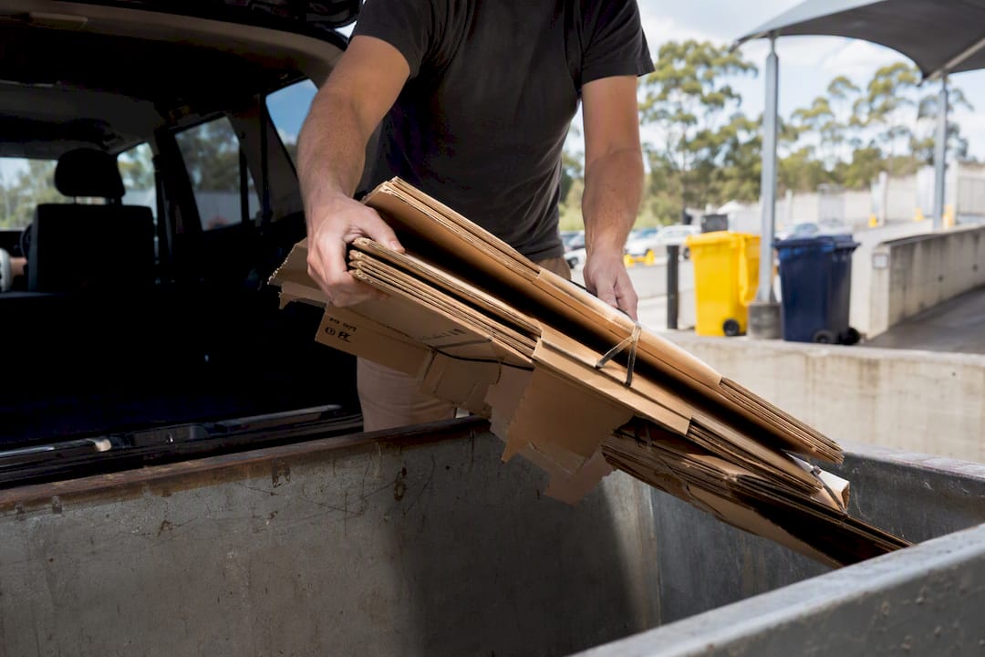Loading flattened cardboard at recycling centre