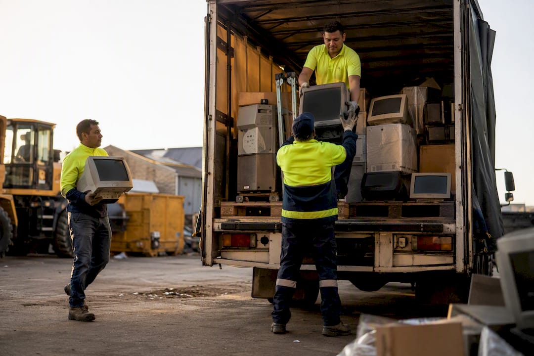 Waste team loading old monitors into truck