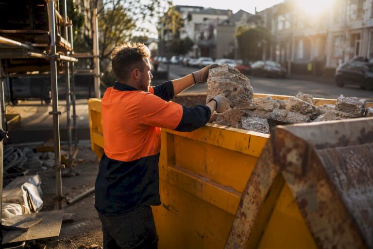 Worker loading broken concrete into trailer