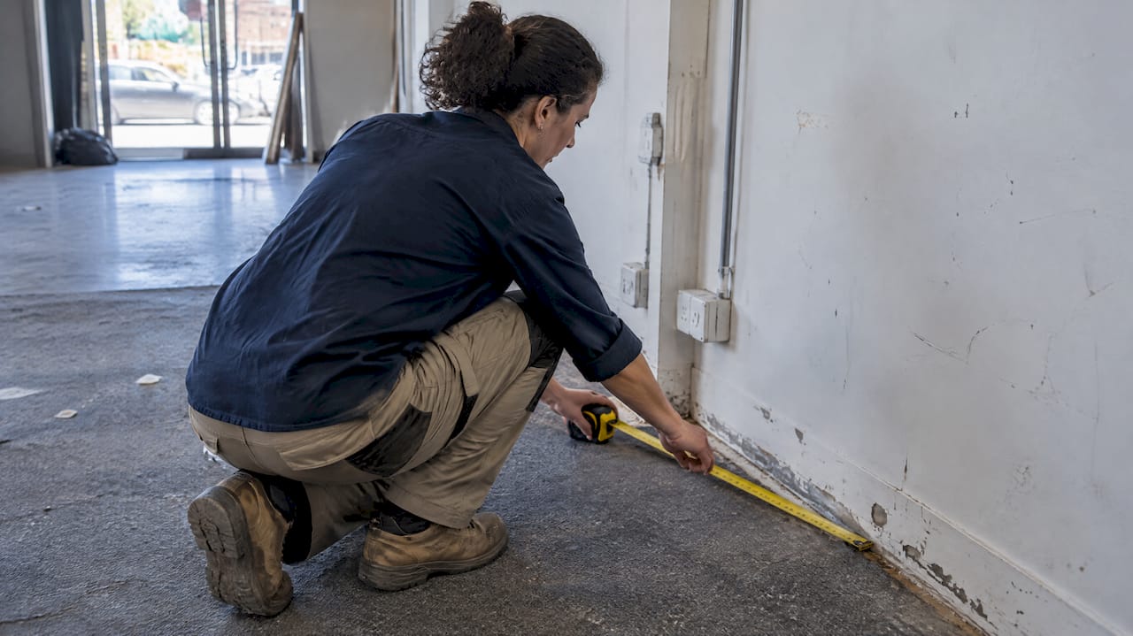 Surveyor measuring worn commercial tenancy condition