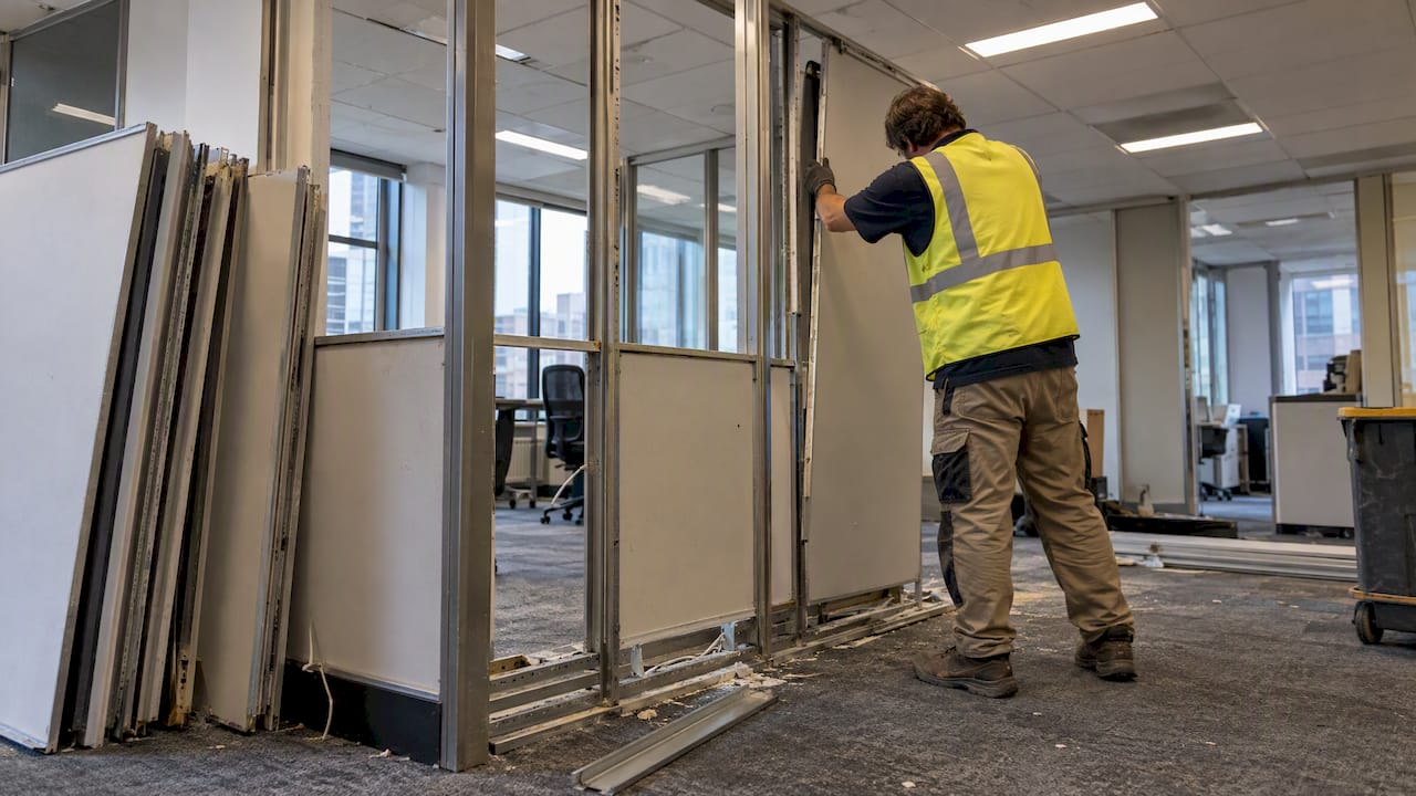 Contractor dismantling office partition panels
